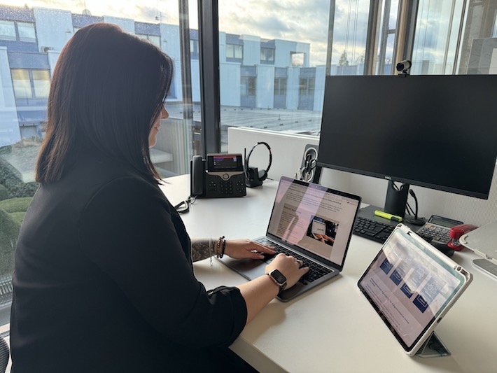 person using macbook air on brown wooden table