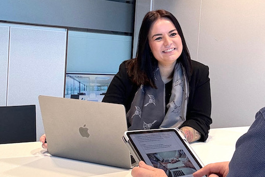 person holding pencil near laptop computer
